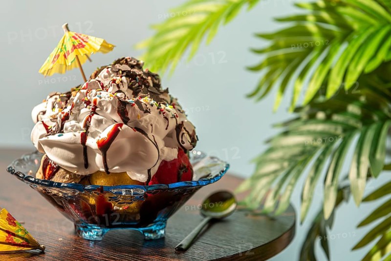 Ice cream with cream, chocolate, crumble and small umbrella