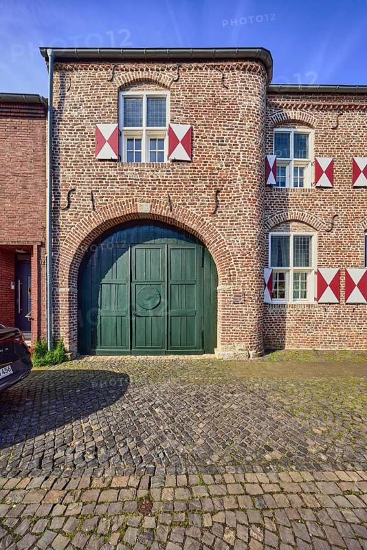 House Wachtendonk, old town center, historic brick building, façade with windows, shutters and wall anchors, gate, entrance gate, walkway, paving stones, blue sky, cirrus clouds, Neustraße, Wachtendonk, Kleve district, North Rhine-Westphalia, Germany