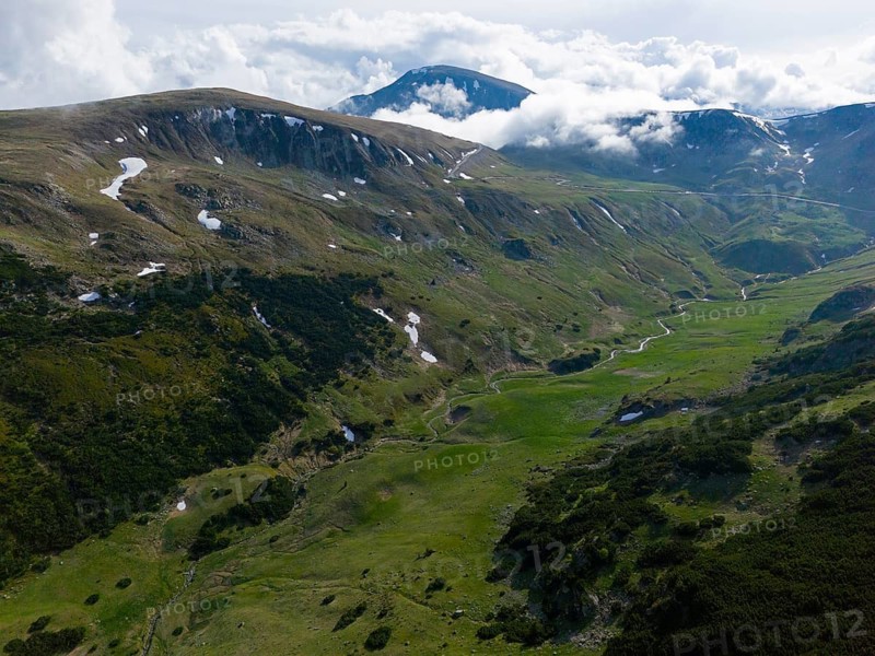 Extensive mountain landscape with green meadows and scattered clouds in the sky, aerial view, near Rânca, Transalpina High Road, Drum na?ional 67C, national road, Transylvania Alps, South Carpathians, Romania