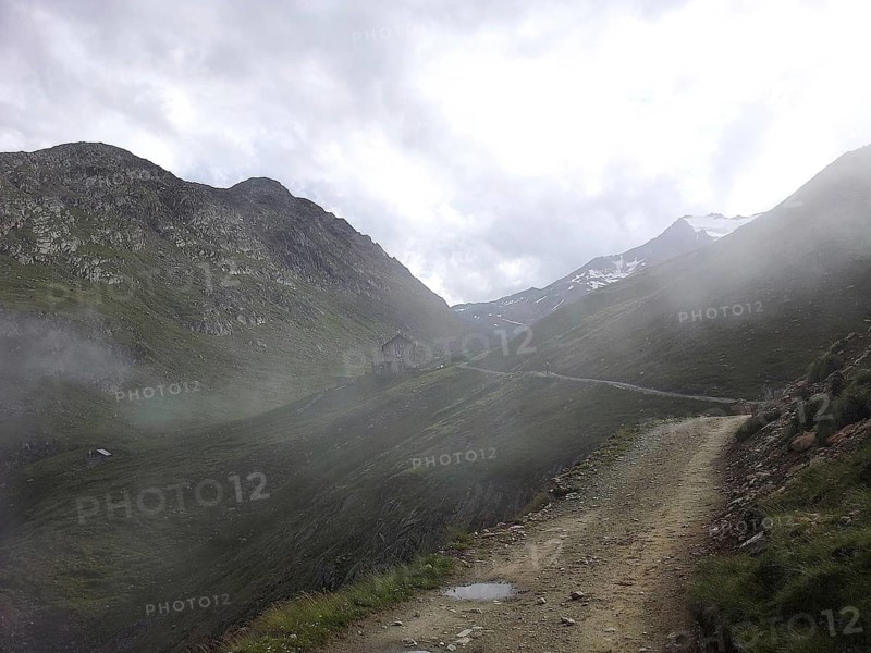 A narrow path winds through a foggy mountain landscape, E5, hiking in the Alps, crossing the Alps, Austria