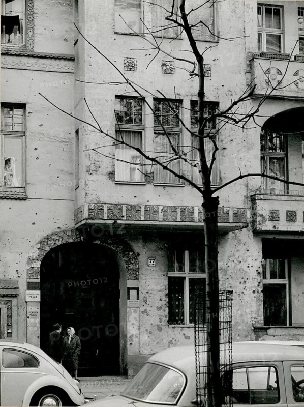 Berlin, Charlottenburg, Niebuhrstr. 77, Gründerzeit buildings, VW Beetles, war damage, West Berlin, an old building with a damaged façade, parked cars and people in the street, Herbert Jacobi (1915–1978), 1966