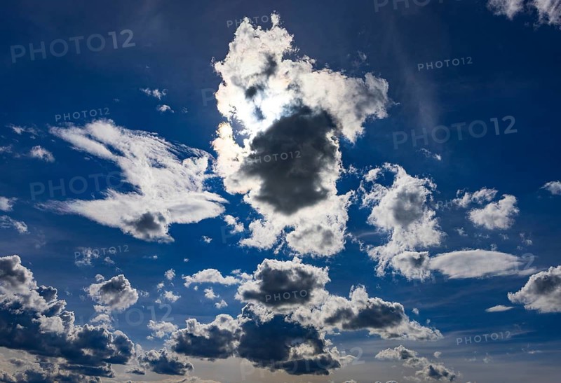 Sun shines between cumulus clouds, dramatic cloudy sky, Austria