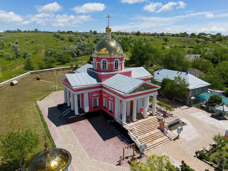 Orthodox village church with golden dome and blooming trees under a blue sky, aerial view, St. George church, Cazaclia, Kazayak, Ceadîr-Lunga district, Ceadir-Lunga, Chadyr-Lunga, Gagauzia autonomous region, Republic of Moldova, Moldova