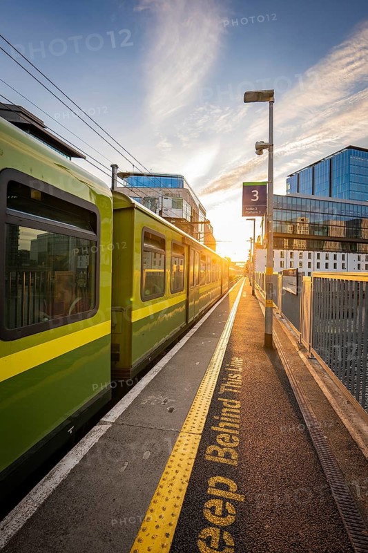 A train on a platform platform at sunset in an urban setting, Docklands, Dublin, Ireland