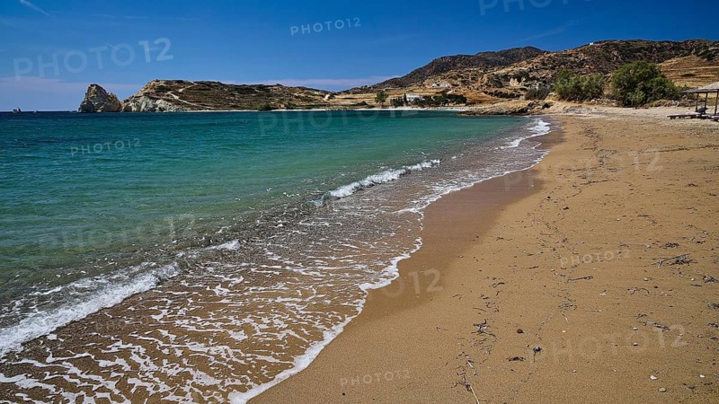 Empty beach with gentle waves, golden sand and blue water under clear skies, Mavorspilia Beach, Kimolos Island, Kimolos, Cyclades, Greek Islands, Greece