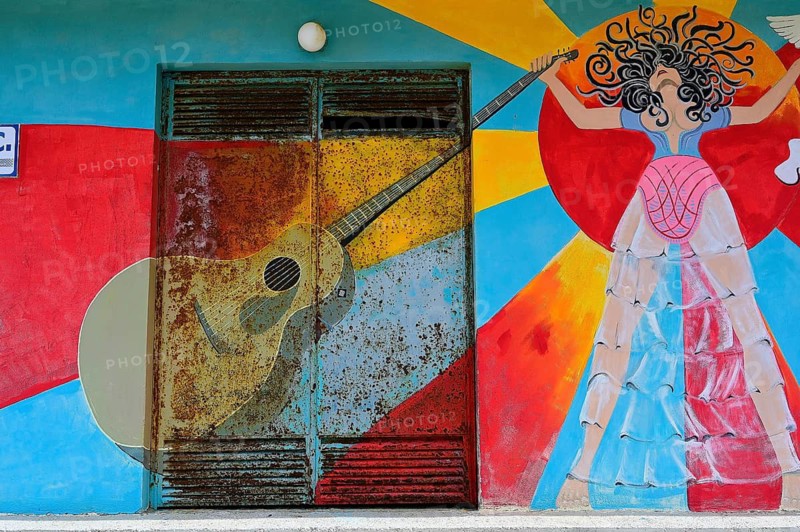 Colourful mural with a guitar and a stylized female figure at a door, Matala, Neolithic caves, former hippie paradise, central south coast, Crete, Greek Islands, Greece