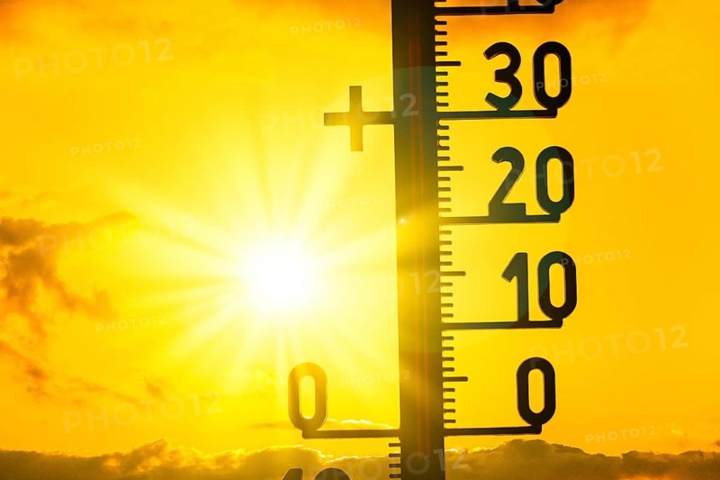 Sun shines intensely behind a thermometer, shows high temperatures in a summer atmosphere, symbolic image, heat, global warming