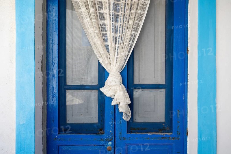 Blue and white front door, white curtain, Malfa, Salina, Aeolian or Lipari Islands, Southern Italy, Italy