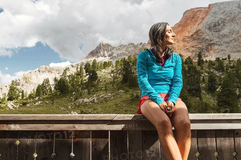 Female hiker resting at mountain hut on Tre Cime trail in Dolomites enjoying alpine scenery wellness adventure and hiking break