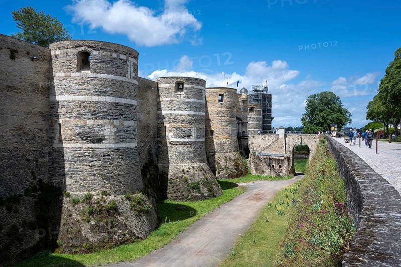 Side view of the monumental medieval fortification with its characteristic striped round towers and deep moats, Château d'Angers, Angers Castle, Angers, Maine-et-Loire, Pays de la Loire, France