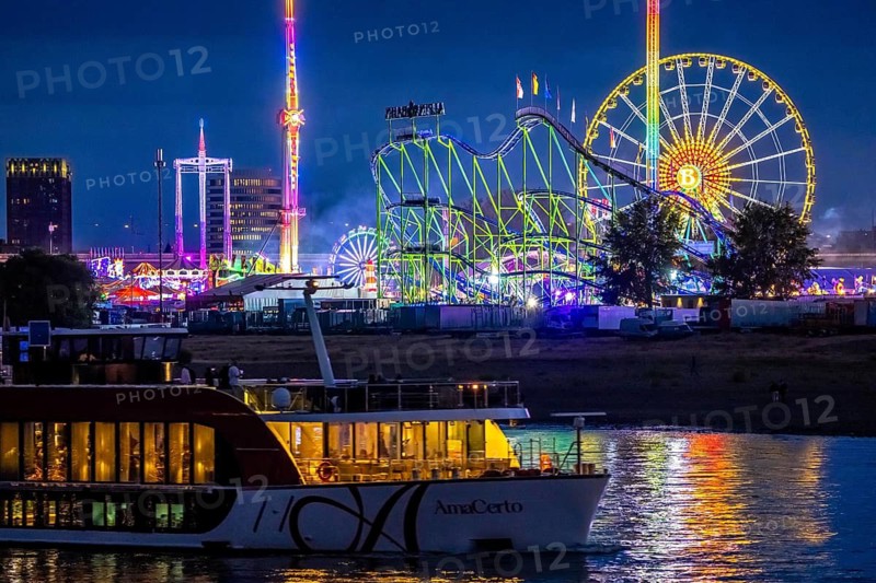 Rhine fair in the Rheinwiesen in Düsseldorf-Oberkassel, rides in the evening, with lots of lighting, Hangover The Tower, Free Fall Tower, Ferris Wheel, Alpina Railway, Rollercoaster, Infinity, Overhead Swing, Gladiator, River Cruise Ship on the Rhine, North Rhine-Westphalia, Germany