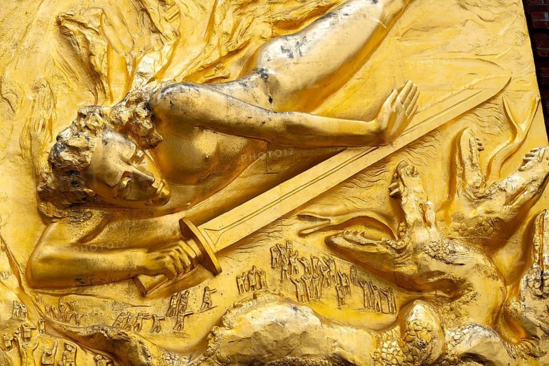 Excerpt from the gilded façade relief The Light Bringer by sculptor Bernhard Hötger, historic Böttcherstraße in the old town of the Hanseatic City of Bremen from the 1920s, example of brick expressionism architecture, brick architecture, popular tourist destination, sword, three-headed snake or dragon creature, Germany