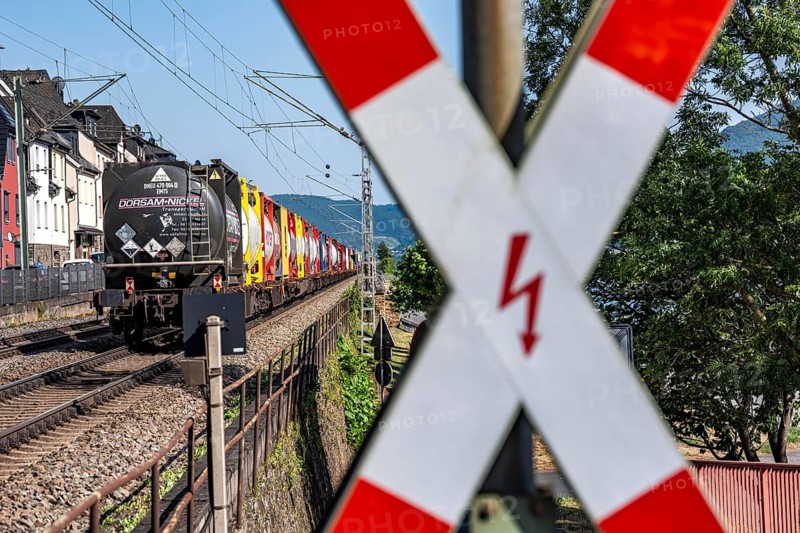 Level crossing, freight train passing through town in Lorchhausen, right next to the residential buildings, railway line on the right bank of the Rhine between Rüdesheim and Koblenz, one of the busiest railway lines in Europe, around 250 trains, including over 150 freight trains, run on the train ticket around the clock, extreme noise pollution for residents, some of whom live a few meters away from the train line, Rhineland-Palatinate, Germany