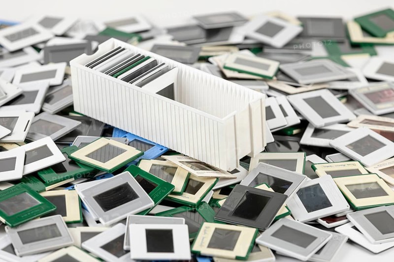 A single slide holder lies in the middle of a chaotic heap of slides