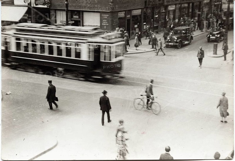 Berlin, Mitte, Unter den Linden, Friedrichstr., traffic, passers-by, classic cars, A tram passes a busy intersection with pedestrians moving, Sasha Stone, around 1928