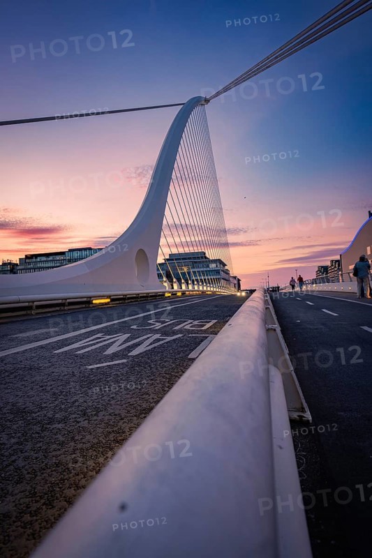 Futuristic bridge at sunset with purple and blue sky, city in background, Samuel Beckett Brg, Dublin, Ireland