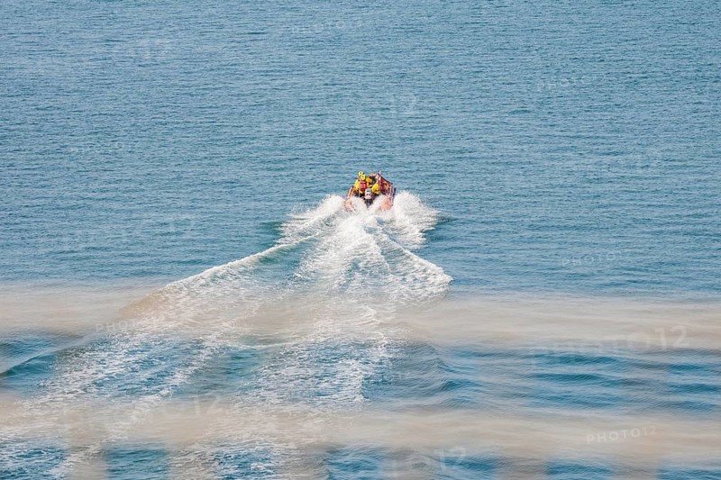 A motor boat draws waves by itself as it travels quickly across the open sea, Howth, Ireland