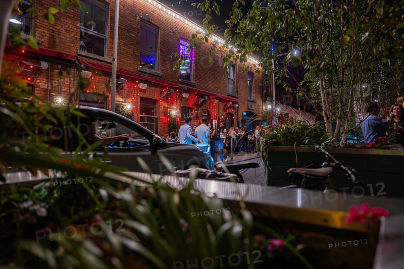 Nighttime street scene with illuminated facades and people enjoying urban nightlife, Nightlife, Dublin, Ireland