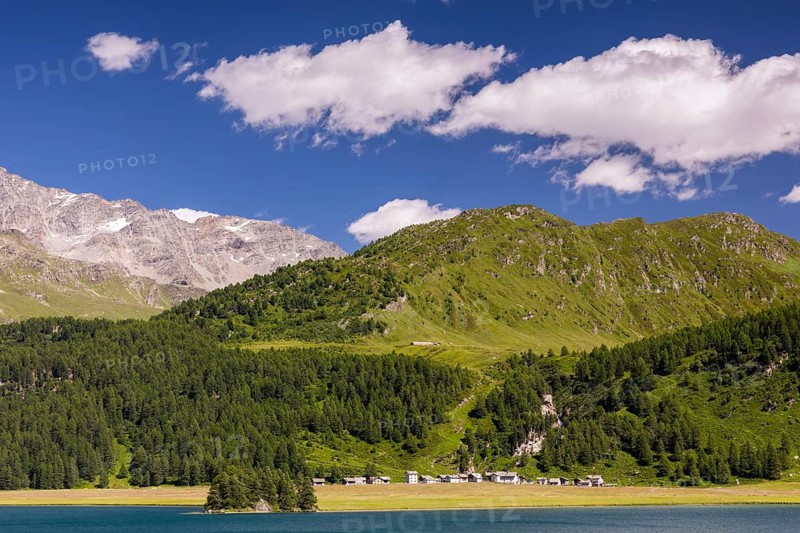 Isola under mountain peaks and in front of Lake Sils, Engadin, Graubünden, Switzerland