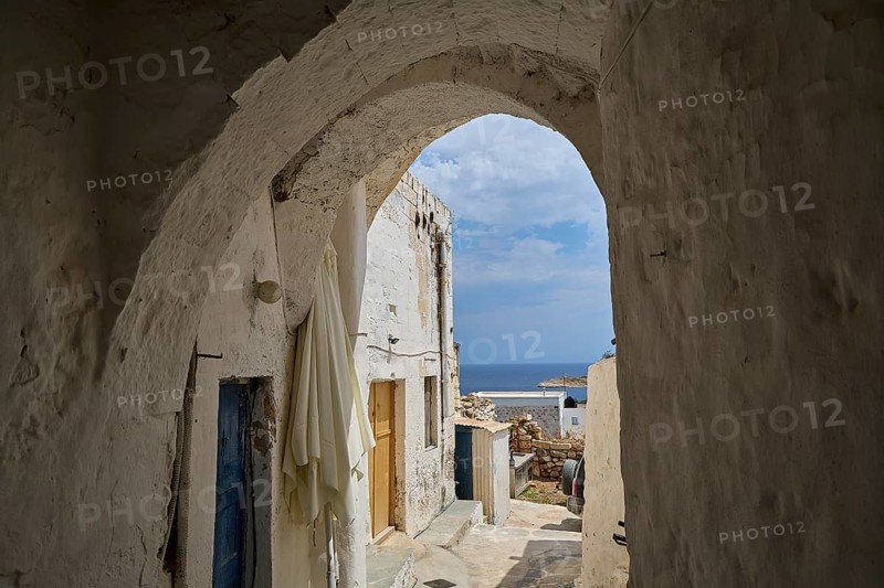 Vaulted passage between white buildings overlooking the sea, main town on Kimolos, Kimolos, Chorio, Kimolos island, neighboring island of Milos, Cyclades, Greek Islands, Greece