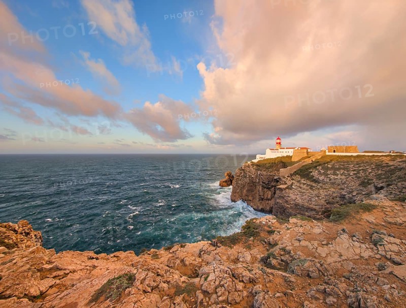 View of the Lighthouse of Cabo de Sao Vicente in Sagres, Algarve, Portugal, at sunrise with Atlantic ocean, cliffs, and sunrise cliff panorama