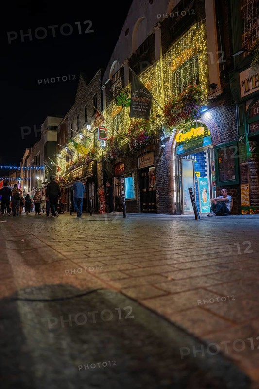 Bustling nighttime street scene with glowing decorations and people in an urban setting, Nightlife, Dublin, Ireland