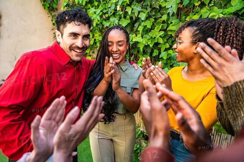 Diverse group of people claps in appreciation and support, celebrating achievements and connections in a therapy session or self help group meeting outdoors