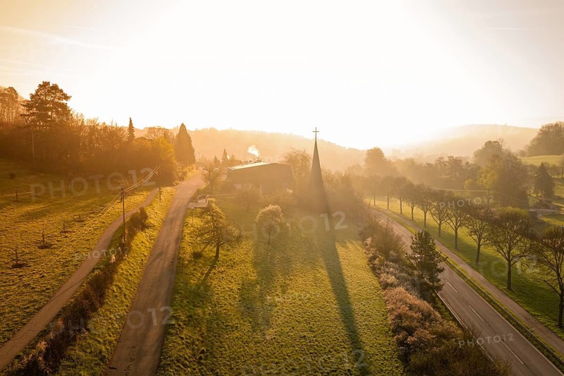 Landscape with church and roads surrounded by trees at sunset, Deufringen, Aidlingen, Heckengäu region, Böblingen district, Germany