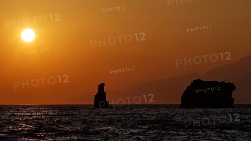 Calm sunset over the sea with a distinctive rock and mountains in the distance, sunset, south of the Amari Basin, Central Crete, Triopetra, rocks in the sea, Crete, Greek Islands, Greece