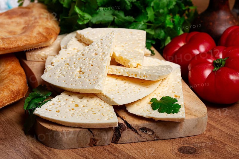 Georgian sliced cheese, on a wooden chopping board, with tomatoes with herbs and lavash, rustic style, Georgian cuisine, no people