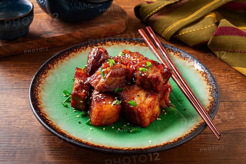 Chinese-style meat with sesame seeds and green onions, on a wooden table, homemade, no people