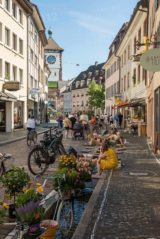 People sitting by and in the stream, Bächle, bathing in the city, heat, heat wave, climate change, Dreisam, Freiburg im Breisgau, Black Forest, Baden-Württemberg, southern Germany, Germany
