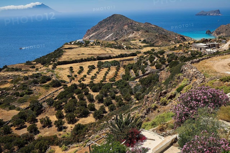 Green hills and vegetation, rocky coasts and blue sea in the distance, Plaka, main town on Milos, island of Milos, volcanic island, Cyclades, Greek islands, Greece