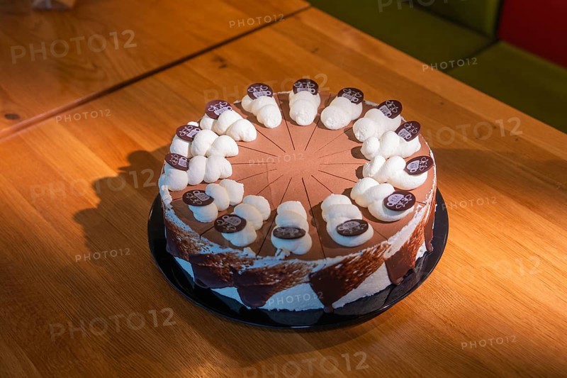 Large chocolate cake with icing and chocolate decorations on a wooden table, Café Kuh, Deckenpfronn, Germany