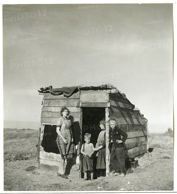 Great drought, Dust Bowl, poverty, hardship, children, impoverishment, migration, USA, Midwest, Farm Security Administration, New Deal, family standing in front of an improvised hut in a rural area, Takonis, mid-1930