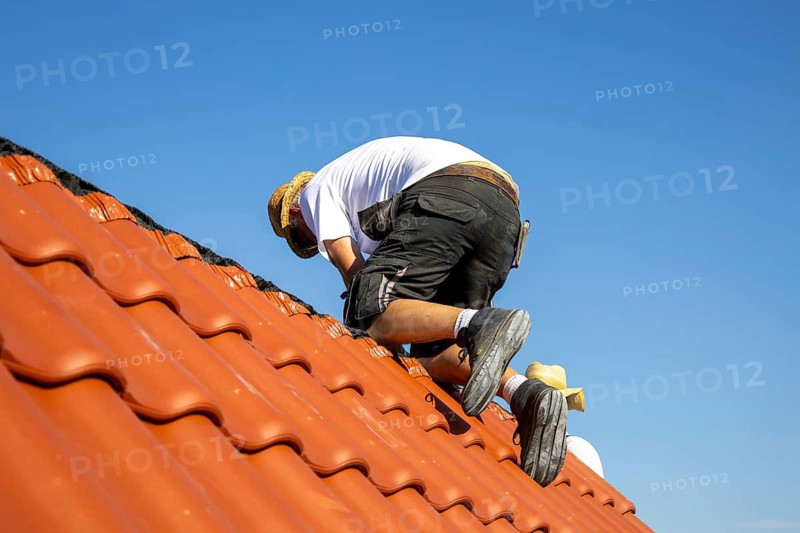 Carpenter or roofer covering a tiled roof in the Palatinate. The temperatures rise to over 35 degrees on this day
