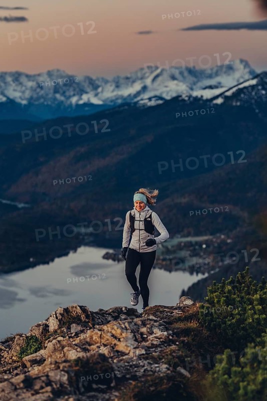 Trail running in autumn on the Jochberg on Lake Walchensee against the wonderful backdrop of the Alps, Bavaria, Germany