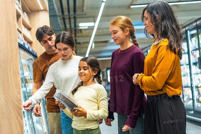 Family comparing products and making choices for fresh food and daily necessities together, fostering consumerism and parenting moments during a grocery shopping trip