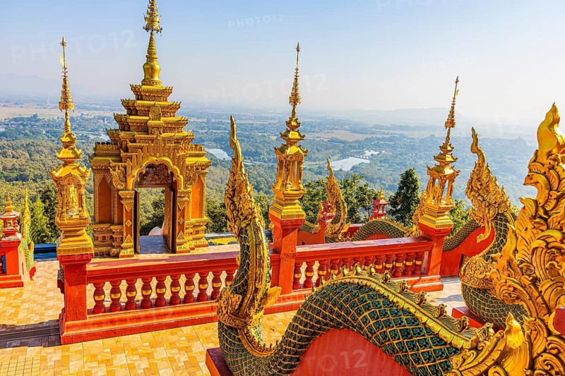 Gilded dragon figures, a gilded pagoda in the back, at the Buddhist temple Wat Phra That Don Phra Chan, near Lampang, Lampang province, Thailand