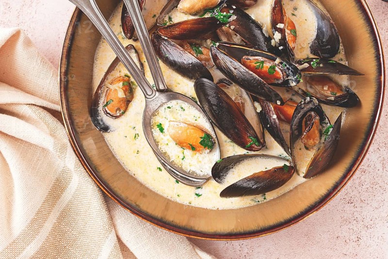 Mussels in creamy garlic sauce, served with fresh herbs and spices, homemade, no people
