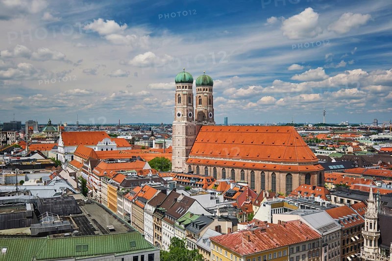 Wide angle aerial view of the iconic Frauenkirche towers and Munich city center architecture under a blue sky in Bavaria, Germany