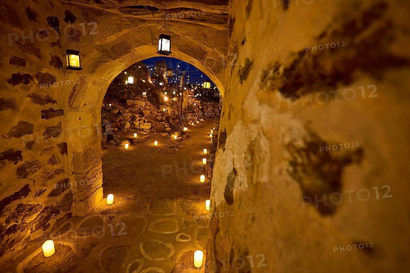 Open-air cinema, a stone archway at night with warm light from lanterns along the way, Kastro, old castle above Chorio, Kimolos, Cyclades, Greek Islands, Greece