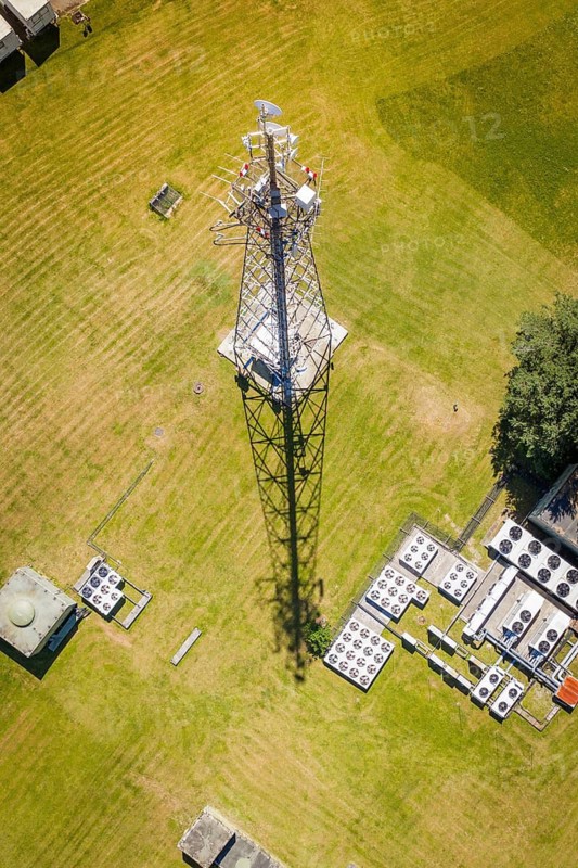 A radio tower towers over the meadow, its shadow is visible, Bunker Anlage, Calw, Germany