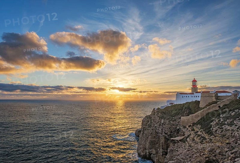 View of the Lighthouse of Cabo de Sao Vicente in Sagres, Algarve, Portugal, at sunset with ocean surf and Atlantic ocean