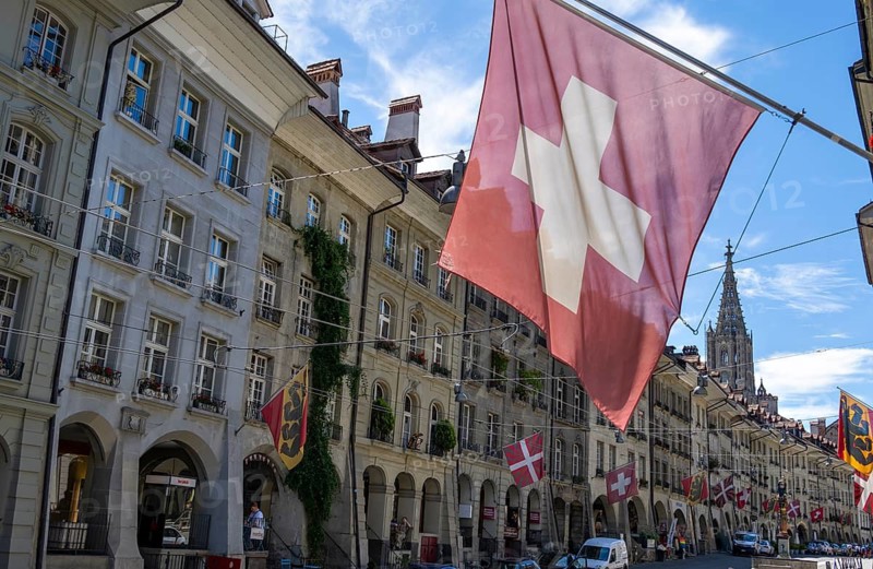Swiss national flag, Gerechtigkeitsgasse with historic houses, old town, Bern, Canton of Bern, Switzerland