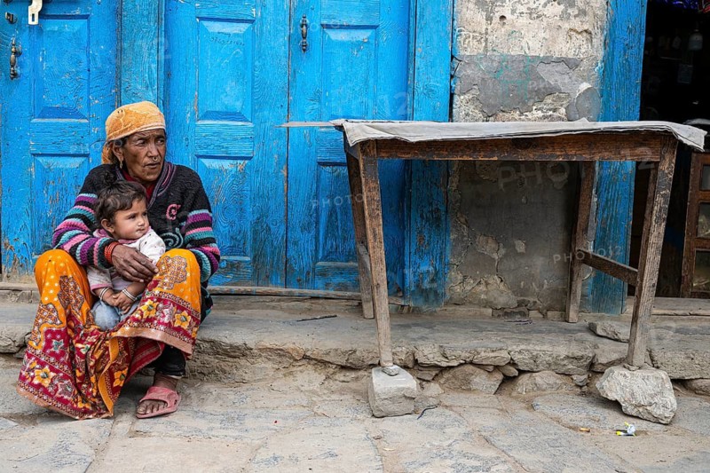 Elderly Nepalese woman with grandchild sitting in front of her house, Hindu ethnic group, Himalayas, Humla region, western Nepal, Nepal