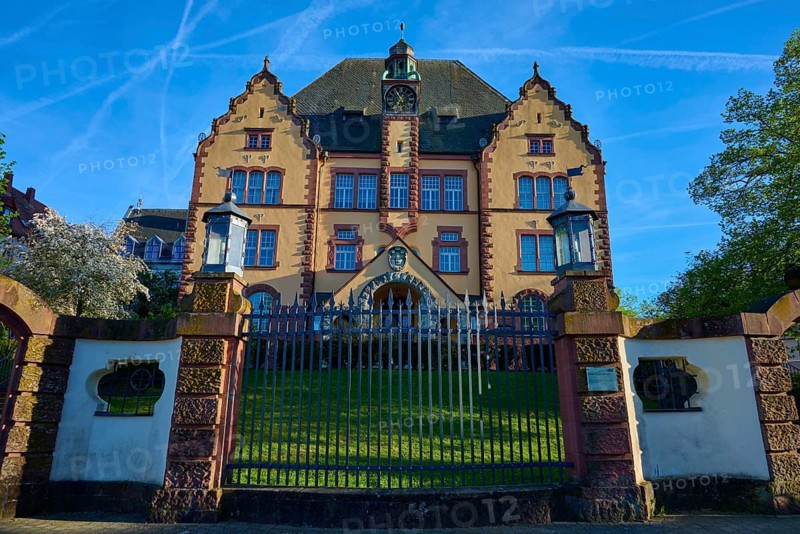 Historic Art Nouveau building behind a gate under blue sky with trees and well-kept lawn, Georg-Ludwig-Rexroth-Realschule, Lohr am Main, Main-Spessart district, Spessart, Mainfranken, Lower Franconia, Bavaria, Germany
