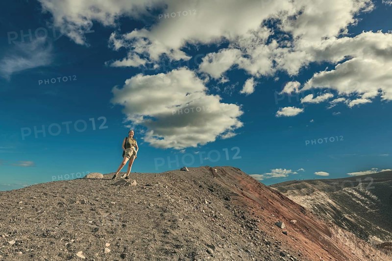 Portrait of a female tourist at the summit of the Cerro Negro volcano. Lifestyle of a girl at the summit of the Cerro Negro volcano