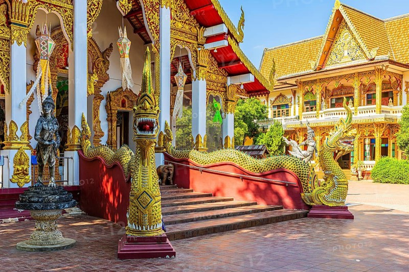 Richly decorated public prayer hall, in front of a staircase with dragon-like beings, in the Wat Chiang Yuen Buddhist temple complex, Chiang Mai, Thailand