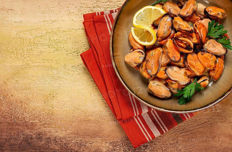 Mussels no shell, boiled, mussels, peeled, in a bowl, with lemon and parsley, Chilean mussels, top view, no people